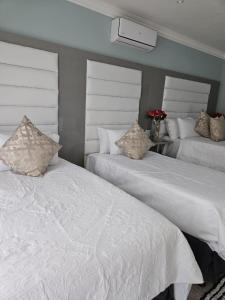 En eller flere senge i et værelse på Elitha Boutique Bed and Breakfast