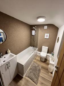 a bathroom with a tub and a toilet and a sink at No 4 John Street in Bethesda