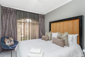 a bedroom with a large white bed and a window at Modern 2 Bedroom apartment with club house pool in Sandton +20 photos