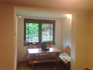 a dining room with a table and a window at Chata Maruska in Ružomberok