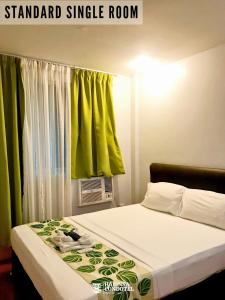 a bedroom with a bed with a green curtain at Haeinsa Condotel in Manila +20 photos