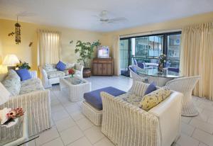 a living room with white wicker furniture and a large window at Colony Cove Beach Resort in Christiansted +6 photos