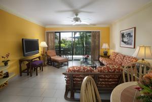 a living room with a couch and a tv at Colony Cove Beach Resort in Christiansted