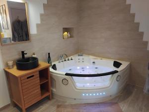 a bath tub in a bathroom with a sink at Ti Gernevez - L'Evasion in Briec