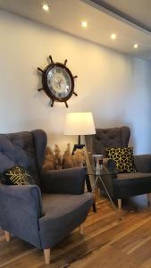 a living room with two couches and a clock on the wall at MiraMar - Parking, wi-fi, Kuchnia ogólnodostępna in Krynica Morska
