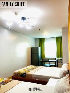 a living room with two beds and a dining room at Haeinsa Condotel in Manila