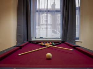 a pool table with balls and bats on it at London 4 Bed Contractor Base with Pool Table in Edmonton +25 photos