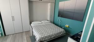 a small bedroom with a bed and a tv at L'Alloggetto sul Corso in Cuneo