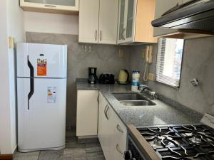 Una cocina con un refrigerador blanco y un fregadero. en Dpto tranquilo pleno Centro-Sur con Cochera, en Santa Fe 5 fotos más