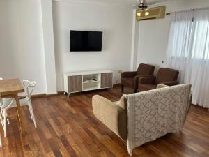 Una sala de estar con un sofá, un televisor y una mesa. en Dpto tranquilo pleno Centro-Sur con Cochera, en Santa Fe