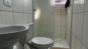 a bathroom with a toilet and a sink and a shower at GUTIERREZ HOTEL in Americana