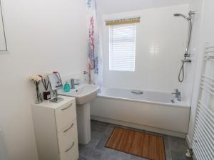 a white bathroom with a tub and a sink at The Sanctuary in Richmond +28 photos