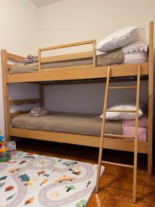 two bunk beds in a room with a rug at Appartamento Cuore delle Dolomiti in Cencenighe