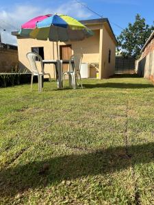 a table and chairs under an umbrella in a yard at Casa da Praia in Itapemirim
