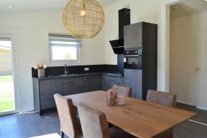 a kitchen with a wooden table with chairs and a sink at Schaelsbergerbosch- 2 Bath FireplGarde in Valkenburg
