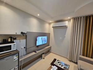 a living room with a tv on a wall at نجمة راحتي للشقق المخدومة العزيزية in Riyadh