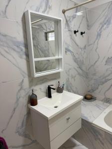 a white bathroom with a sink and a mirror at Casa en Tanti con pileta in Tanti