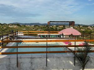 a swimming pool with an umbrella and a swimming poolvisor at Casa en Tanti con pileta in Tanti