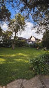 una casa en un patio con césped verde en Refúgio da VILLA, en Gramado