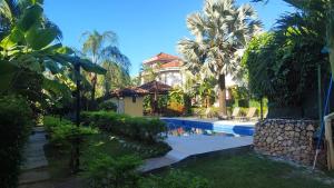 a house with a swimming pool and palm trees at Casa Sueno Colibri in Tamarindo