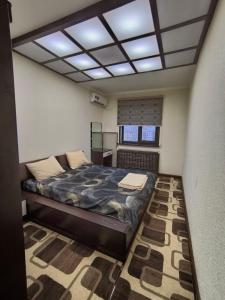 Un dormitorio con una cama grande y una ventana en Aybek, Chekhova 21, en Toshkent-Passajir Bekati