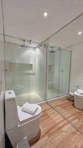 Un baño con inodoro y ducha de cristal. en Refúgio da VILLA, en Gramado