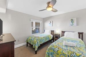Un dormitorio con dos camas y un ventilador de techo. en Beach Front Penthouse Stay Salty 602, Free Activities Included!, en Fort Walton Beach 36 fotos más