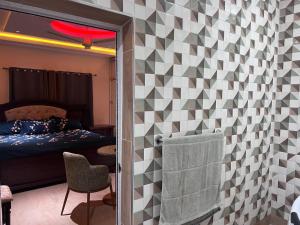 a room with a bedroom with a bed and a chair at T-Roys Apartments in Accra +97 photos