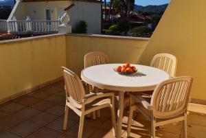 a table with chairs and a bowl of fruit on a balcony at Anacasa Picasso Oliva Nova CH1400 in Oliva