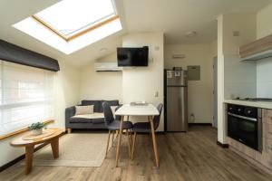 a small living room with a table and a kitchen at Studios y Departamentos Nómades del Lago in Puerto Varas