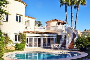 ein Haus mit einem Swimmingpool davor in der Unterkunft Anacasa Villa Renoir Oliva Nova CH1015 in Oliva