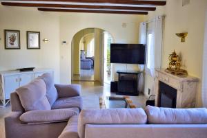 ein Wohnzimmer mit zwei Sofas und einem Kamin in der Unterkunft Anacasa Villa Renoir Oliva Nova CH1015 in Oliva