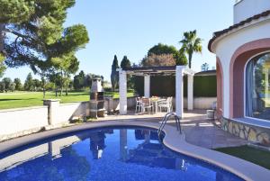 einen Pool im Hinterhof mit einem Tisch und einer Terrasse in der Unterkunft Anacasa Villa Murillo Oliva Nova MET CH1900 in Oliva