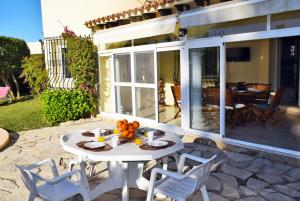 ein weißer Tisch und Stühle auf einer Terrasse in der Unterkunft Anacasa Villa Renoir Oliva Nova CH1015 in Oliva