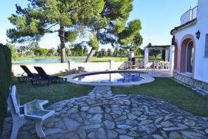 eine Terrasse mit Stühlen und einem Pool im Hof in der Unterkunft Anacasa Villa Murillo Oliva Nova MET CH1900 in Oliva