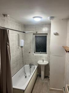 une salle de bain avec une baignoire et un lavabo dans l'établissement Garden Street Retreat in Wigston, à Glen Parva