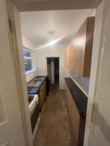 une cuisine avec un évier et une cuisinière dans l'établissement Garden Street Retreat in Wigston, à Glen Parva