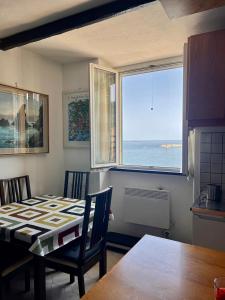 Una cocina con mesa y vista al mar. en La Nicolina, en Santa Margherita Ligure