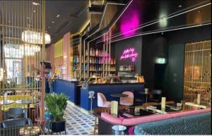 a restaurant with pink chairs and a bar at KAYA Zurich Apartment 5A - Downtown 2-BR Deluxe Loft Apt in Zürich +25 photos