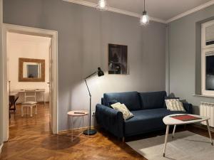 Una sala de estar con un sofá azul y una mesa. en Apartamenty Zasanie, en Przemyśl
