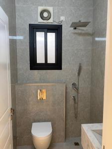 a bathroom with a toilet and a window and a shower at Samo Apartment in Taif +37 photos