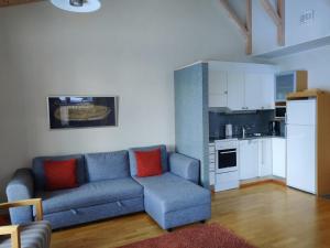 a living room with a blue couch and a kitchen at Kylpyla SPA, Saimaa Villa B3 in Imatra