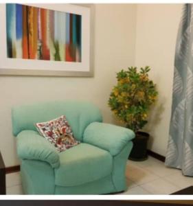 a blue chair with a pillow and a plant in a room at 3-Beds Nalaksuites - Selfcatering apartments in Gaborone