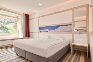 a bedroom with a bed and a large window at Hotel Han Bjelašnica in Bjelašnica +53 photos