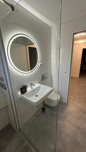 a bathroom with a sink and a mirror and a toilet at Ruhige Wohnung mit Garten in Schönefeld +5 photos