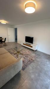 a living room with a couch and a flat screen tv at Ruhige Wohnung mit Garten in Schönefeld