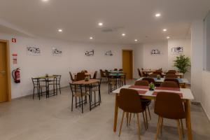 a restaurant with tables and chairs in a room at Figuras Mágicas in Trancoso