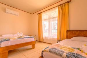 a bedroom with two beds and a window at Casa vacacional cerca de la Fortuna San Carlos in Tanque +14 photos