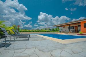 a patio with two chairs and a swimming pool at Casa vacacional cerca de la Fortuna San Carlos in Tanque
