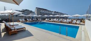 a swimming pool with chairs and umbrellas on a building at Apartamento San Bartolo in San Bartolo